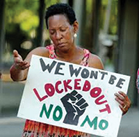 New Orleans resident Marlene Kennedy prays during a 24-hour vigil hosted by VOTE, Stand with Dignity, and other advocacy groups. The vigil outside the city’s housing authority was designed to draw attention to bans on people with criminal records living in public housing. Ms. Kennedy was an inmate in St. Gabriel Prison. Image by Eliot Kamenitz of the <em>New Orleans Advocate</em>.