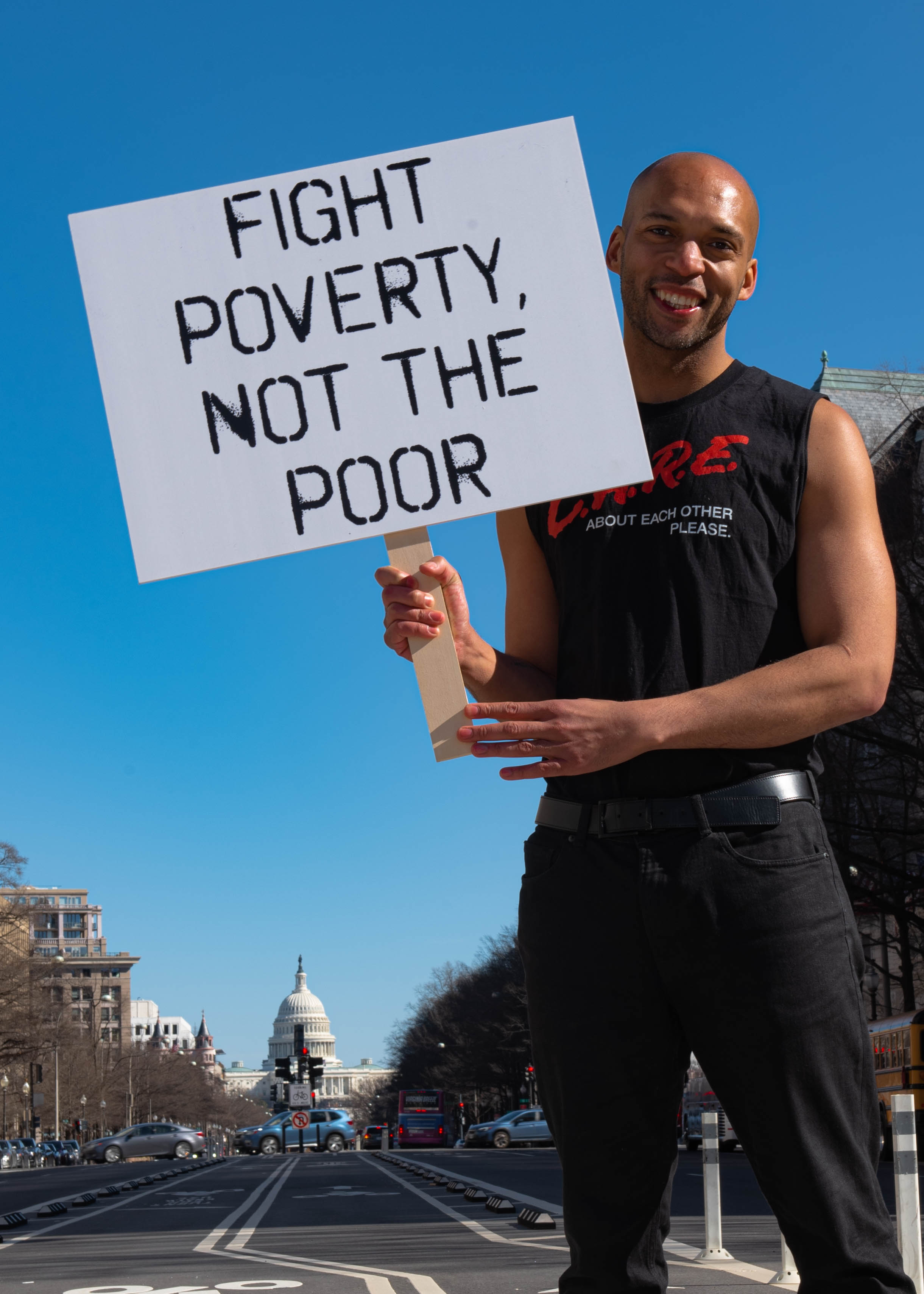 Tyrone with a sign saying “Fight poverty, not the poor."