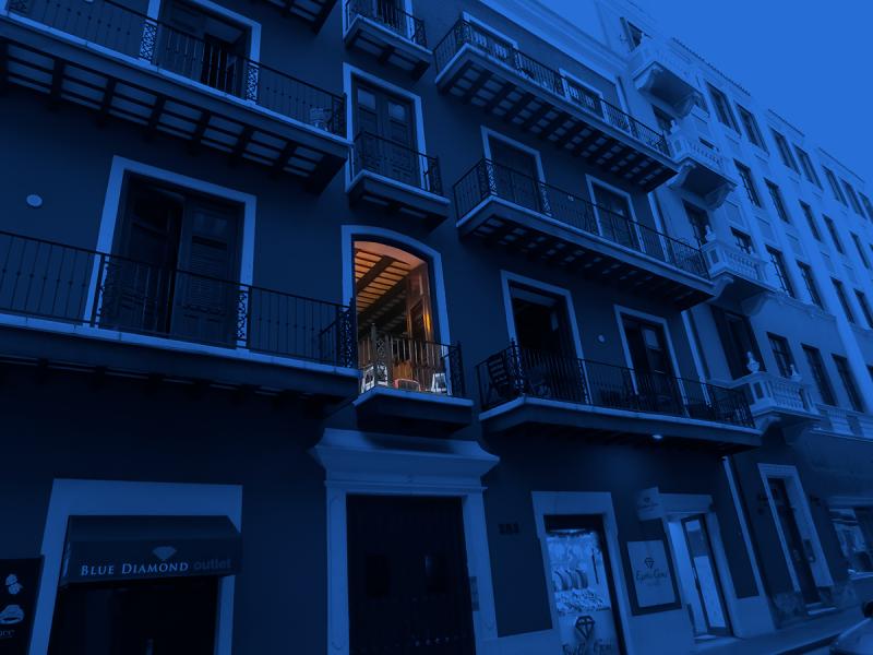 Housing building with a dark blue overlay and one unit with a light on.