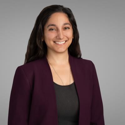 Profile photo of Ramina Davidson, with long dark hair, smiling, wearing a purple jacket.